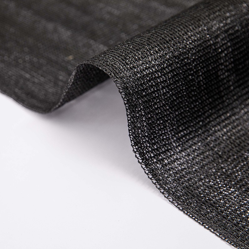 Black tape HDPE shade net fabric held up showing the knitted mesh