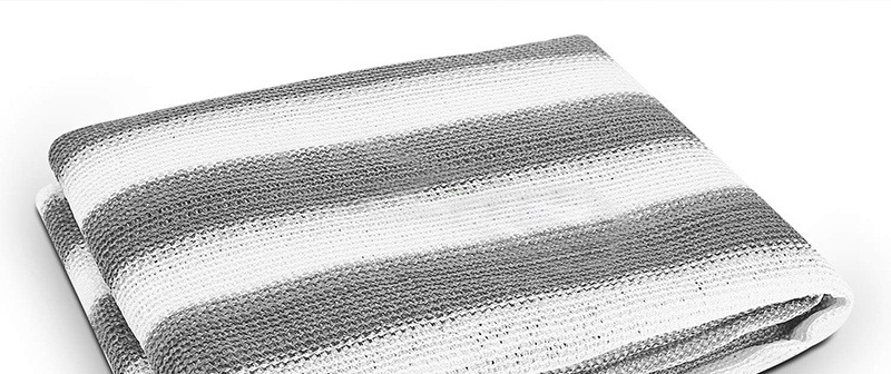 Folded grey and white striped HDPE sun shade net on a white background