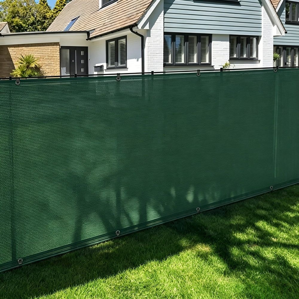 Green HDPE privacy fence mesh screen fitted along a garden fence