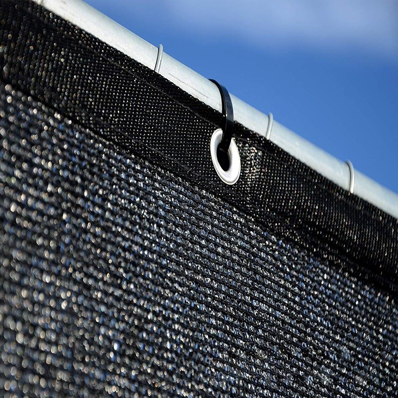 Privacy screen mesh tied to a fence with a grommet and tie in close view
