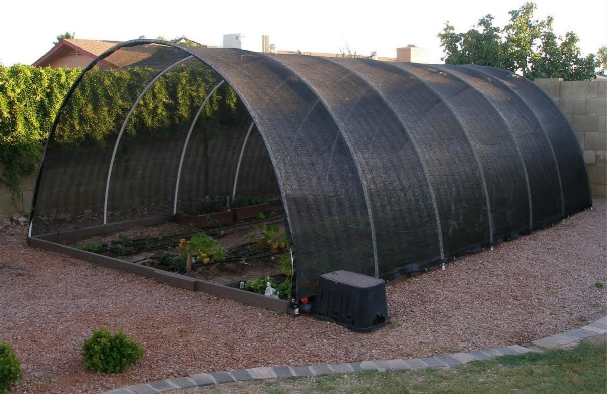 Black HDPE sunblock shade cloth covering a hoophouse over planted beds