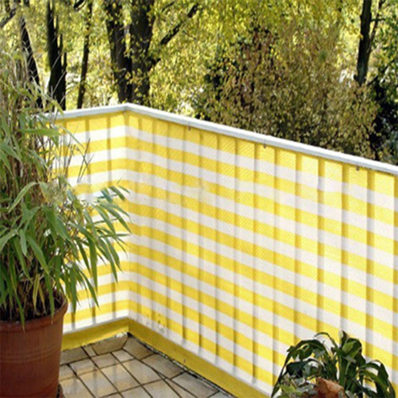 Yellow and white striped HDPE sun shade net fitted to a balcony with planting