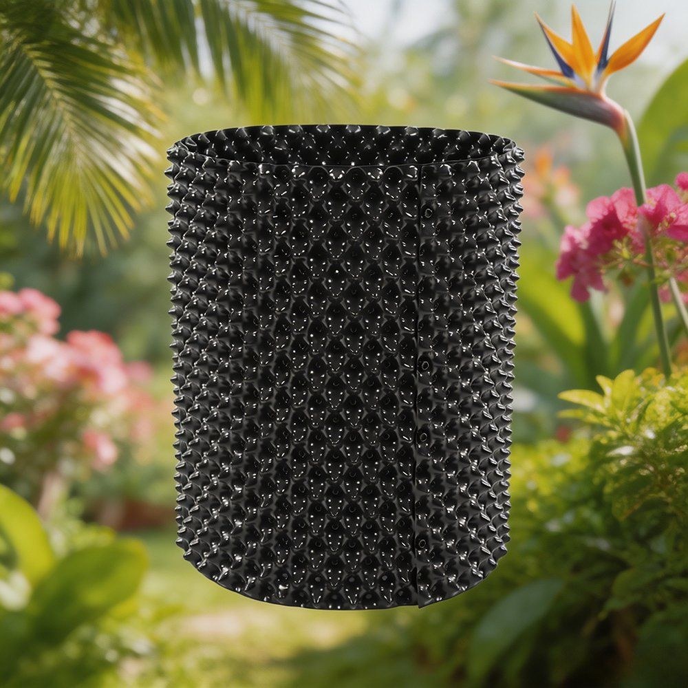 black air pruning pot standing among tropical plants in a garden